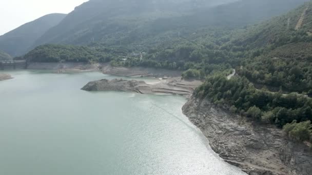 減少した湖の水位に対する空中ドローンの眺めフランスのピレネー山脈の距離にあるダムの眺めとAyous湖 水平4Kビデオ — ストック動画
