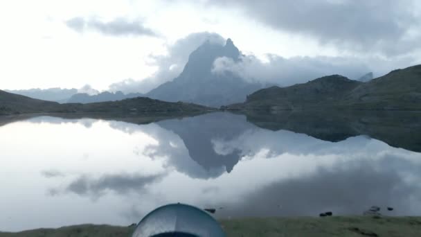 美しいドローンビュー転送は フランスのピレネー山脈の白い雲で覆われた山脈に至るまで撮影しました 湖の横にキャンプテント 水平4Kビデオ — ストック動画
