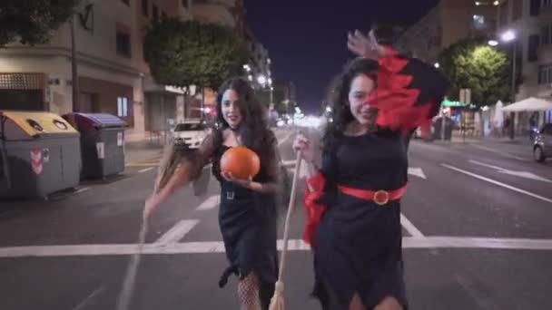 Две Симпатичные Девушки Идущие Пустой Дороге Костюмах Хэллоуин Движущаяся Средний — стоковое видео