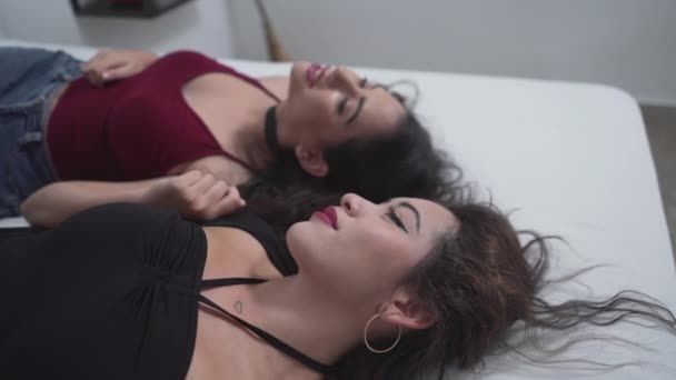 Duas Amigas Vestindo Maquiagem Sexy Tops Deitado Lado Lado Cama — Vídeo de Stock