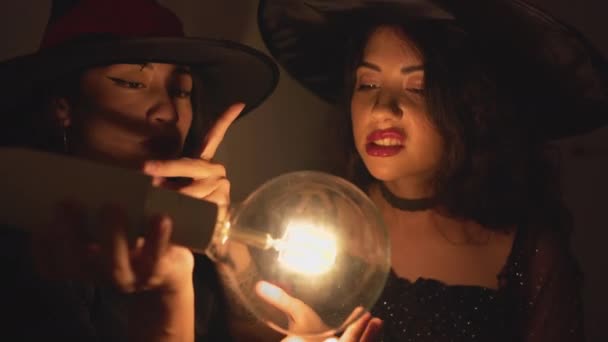 在西班牙瓦伦西亚的一间黑暗的公寓房间里 两名身穿万圣节服装 头戴女巫帽的哥伦比亚妇女在透明的小灯泡周围挥动着双手 Closeup Shot 水平4K — 图库视频影像