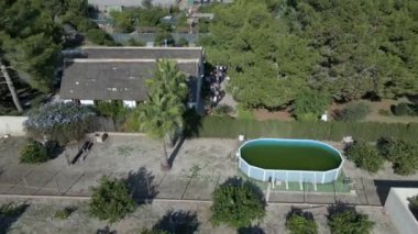 Aerial backward movement of a village by the side of a canal by the lake with the view of houses with green vegetation all around in Albufera natural park in Spain. - 4K Horizontal video