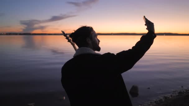 西班牙阿利坎特的Torrevieja Pink Lake拍摄了西班牙胡子吉他手在日落时带着吉他自拍的照片 水平4K视频 — 图库视频影像