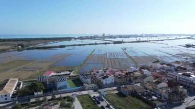 İspanya 'nın Albufera doğal parkında mavi gökyüzü ile suya batmış Tarım Köyü' nün insansız hava aracı görüntüleri. Arabalar hareket ediyor, güzel doğa manzarası. - 4K Yatay Görüntü