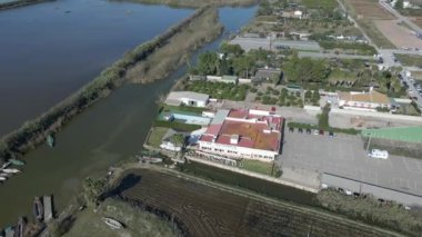 İspanya 'daki Albufera doğal parkında mavi gökyüzü ile suya batırılmış tarımsal tarlaların ve su sularının güzel hava aracı görüntüsü. - 4K Yatay Görüntü