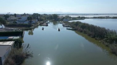 Valencia, İspanya 'daki Albufera doğal parkını ziyaret etmek için turistli teknelerin hava aracı görüntüleri. Doğal parkın güzelliği. - 4K Yatay Görüntü