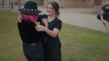 photographer recording two young female models hugging each other warmly - Horizontal 4K video