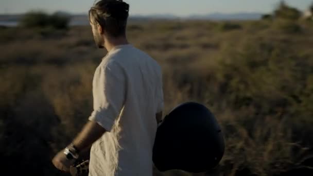 Spaanse Hipster Man Met Een Gitaar Loopt Door Een Grasveld — Stockvideo