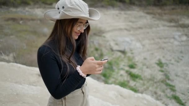 Dark Haired Girl Hat Glasses Outdoors Laughs While Using Phone — ストック動画