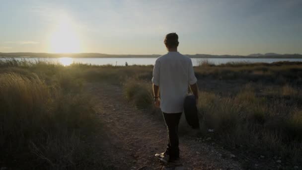 Man Met Gitaar Draaiend Een Cirkel Tegen Prachtige Zonsondergang Horizontale — Stockvideo