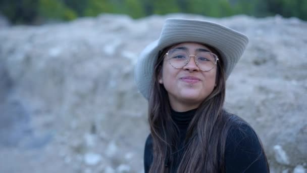 Молодая Женщина Природе Шляпе Очках Жует Еду Улыбается Горизонтальное Видео — стоковое видео