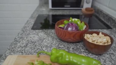 Kadın eli, mutfak bıçağıyla yeşil biberi dilimliyor. - Kapat - Yatay