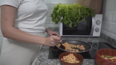 Mutfakta yemek pişirirken tatlı bayan yemekleri tadıyor. Ortalama çekim, eğiklik - Yatay