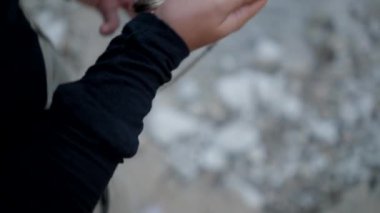 Kız ellerinin cepten pusulayı alıp yatay olarak kullanışının yan görüntüsü.