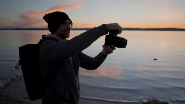 Joven Fotógrafo Tomando Fotos Con Una Cámara Profesional Junto Lago — Vídeo de stock