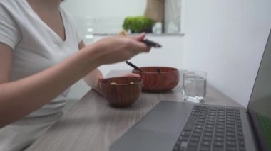 Diz üstü bilgisayarın yanında ahşap teçhizat ve kase kullanan biri. Yakın plan - Yatay