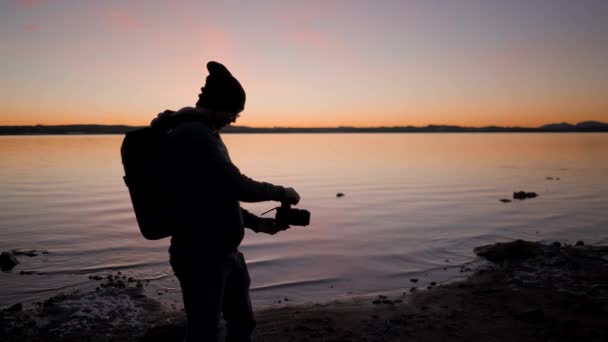 摄影师在日落时在湖边拍照的轮廓 水平4K视频 — 图库视频影像