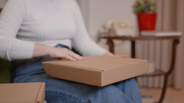 Kadın girişimcinin elleri teslimattan önce paket kutularını kontrol ediyor. - Yatay 4K videosu