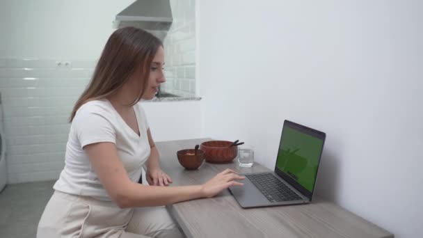 Молода Жінка Їсть Їжу Сидячи Перед Ноутбуком Будинку Середній Постріл — стокове відео