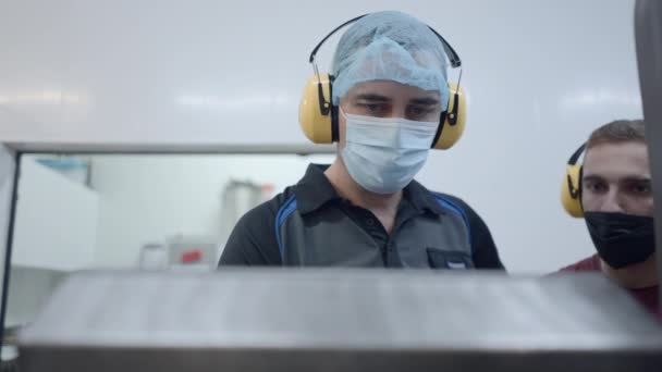 Beer Factory Operators Wearing Headphones Facemasks Workplace Medium Shot Horizontal — Stockvideo