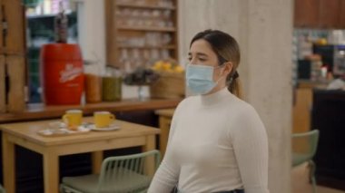 Kafeteryadaki koruyucu maskeli kadın maskesini çıkarıp birlikte çalışan uzay ofisine girdiği için yüz yüze güvenlik sistemini tanıtacak.