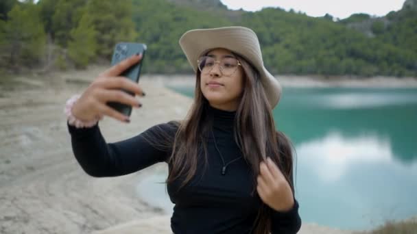 Dark Haired Girl Hat Glasses Takes Selfie Lake Close View — ストック動画