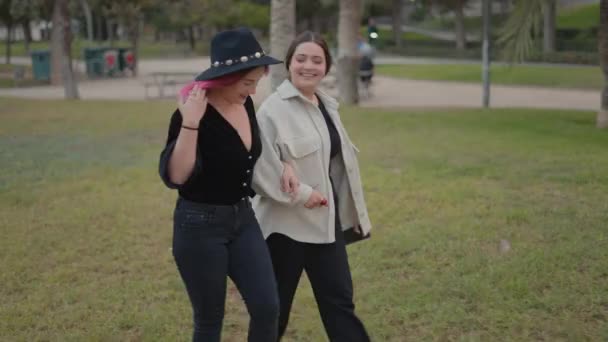 Stylish Smiling Friends Walking Park Holding Hands Slowmotion Horizontal Video — Vídeo de stock