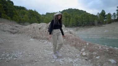 İspanya 'da gölün kıyısında yürüyüş yapan genç bir kadın durur ve pusulaya bakar.