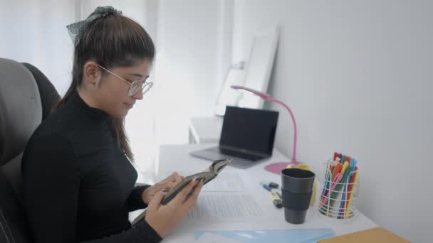 Молодий Студент Колумбійської Універсальності Сидить Столом Читаючи Книжку Пишучи Нотатки — стокове відео