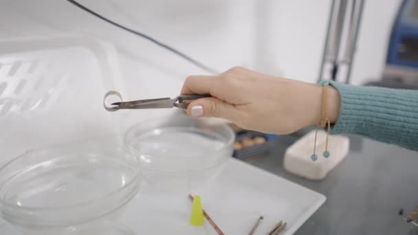 Jeweler Tweezer Puts Metal Crystal Clear Bowl Liquid Shop Closeup — Stockvideo