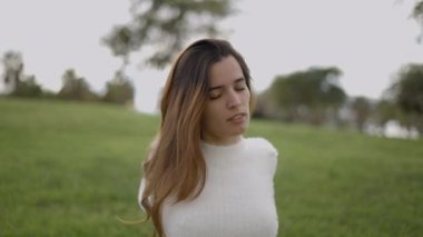 Açık havada sırtüstü uzanan genç bir kadının yakın portre çekimi - 4K Yatay Görüntü