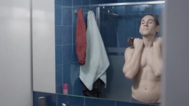 Genç karidessiz adam aynanın önünde sert bir fırça alıp hazırlıyor - yavaş çekim - yatay video