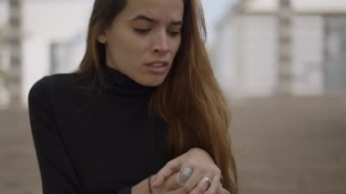 Siyah elbiseli genç, siyah saçlı kadın dışarıda ağlıyor, yakın çekim pan - 4K yatay video