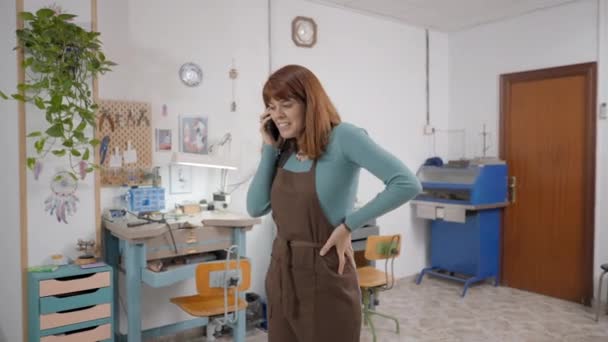 Freelance Jeweler Talking Her Smartphone Wearing Apron Her Workroom Medium — Stok video