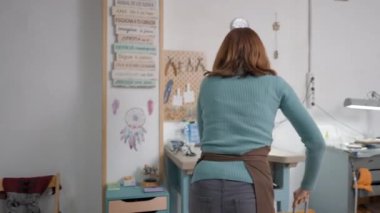 Yetenekli genç bir zanaatkar, küçük not defterine suç ortağı olarak bakıyor. Orta Çekim 4K Yatay Görüntü