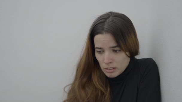 Jovem Mulher Assustada Senta Canto Quarto Olha Para Baixo Perto — Vídeo de Stock
