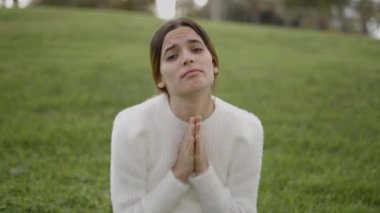 Portrait shot of young dark-haired woman begging with face and hands - 4K Horizontal video