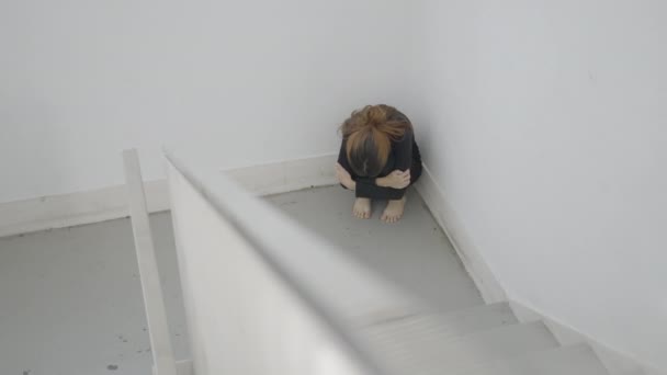 Young Scared Woman Sits Curled Corner Stairwell Horizontal Video — Video