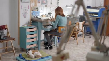 Genç bayan kuyumcu evcil hayvan için kurnaz mücevherler yapmak için testere kullanıyor. Seçici Odaklanma Görüntüsü 4K Yatay Görüntü