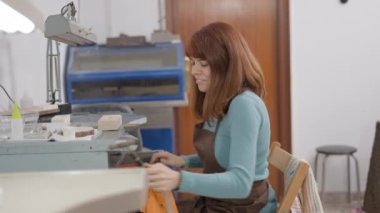 Genç Kuyumcu Blowtorch 'u yakıyor ve işyerindeki alevi ayarlıyor. Orta Çekim 4K Yatay Görüntü