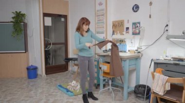 Şirin genç zanaatkar dükkanında köpek yalanıyla önlük takıyor. Geniş Görüntü 4K Yatay Görüntü