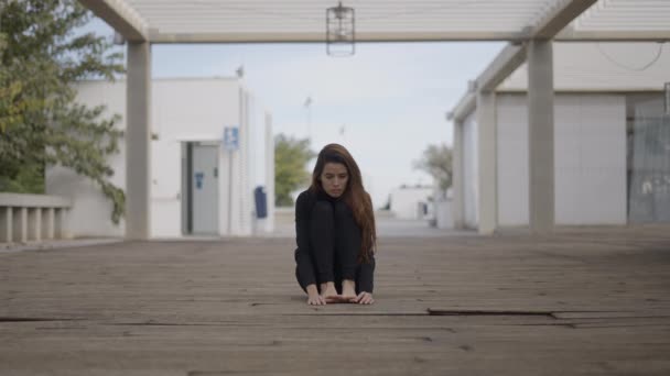 Genç Kadın Ahşap Köprüde Oturuyor Korkmuş Görünüyor Ortalanmış Yatay Video — Stok video