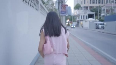 The girl is walking down the street, calling back her friend - 4K Horizontal video