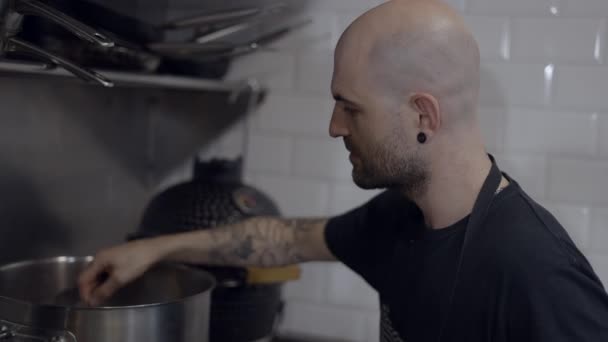 Tattooed Male Chef Tastes Food Spoon Kitchen Close Slomo Horizontal — 图库视频影像