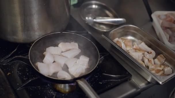 Близкий Обзор Повара Жарящего Куски Белой Рыбы Газовой Плите Кухне — стоковое видео