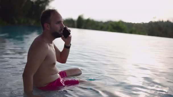 Middle Age Man Smartphone Sitting Swimming Pool Sunset Taking Phone — Stockvideo