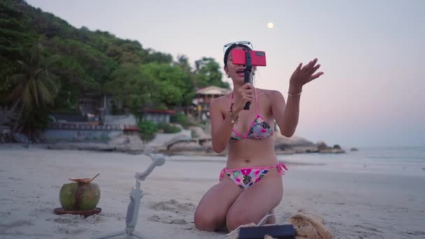Happy Asian Girl Takes Video Live Broadcasting Beach Sunset Wearing — Vídeos de Stock