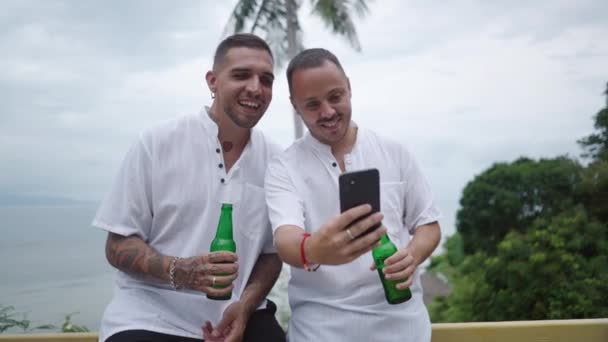 Two Happy Men Gay Couple Honeymooners Holding Beer Watching Phone — 图库视频影像