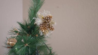 Evde Noel ağacının tepesine çam kozalağı süslemeleri. Kapat - Yatay 4K videosu