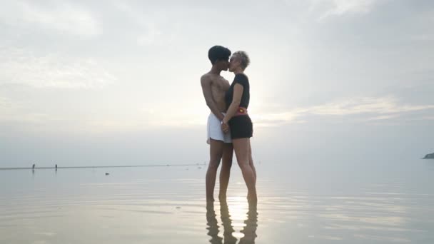 Silhouetted Couple Kissing Sunset Standing Shallow Calm Sea Water Sunlight — Vídeos de Stock